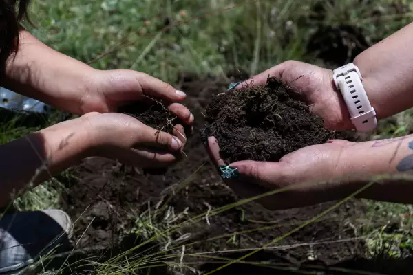 manos agarrando la tierra sembrando