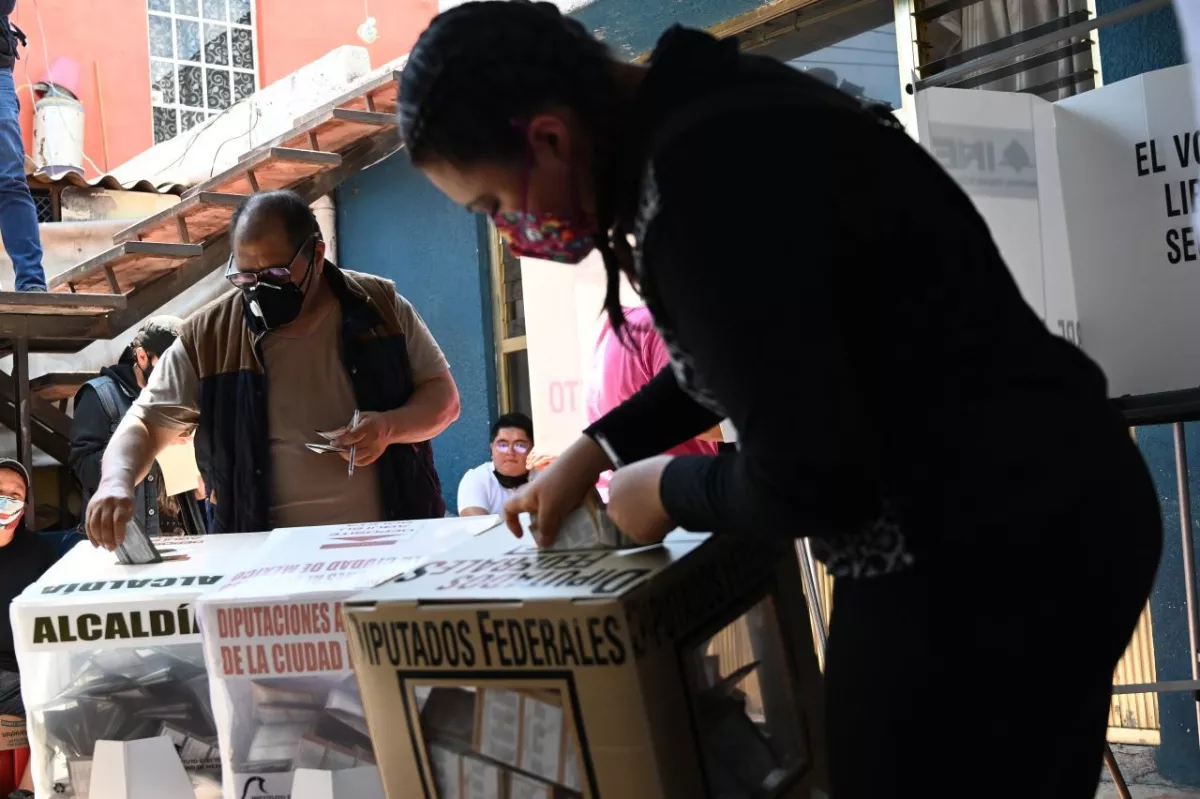 Dos habitantes de Iztapalapa colocan sus votos dentro de las urnas.