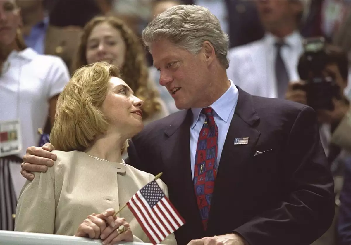 Hillary Clinton, left, and Bill Clinton look to one another as the USA women's 4x200m freestyle rela