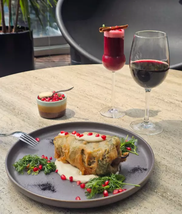 foto de una mesa del restaurante del hotel W Polanco con un chile en nogada, una copa de vino y un coctel mexicano