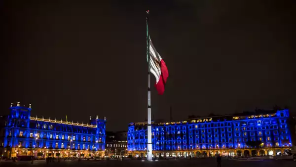 Huge Mexican flag on flagpole at the Mexico City's main square or Zócalo, officially known as the Plaza de la Constitución or Constitution square at night, Mexico City, Mexico