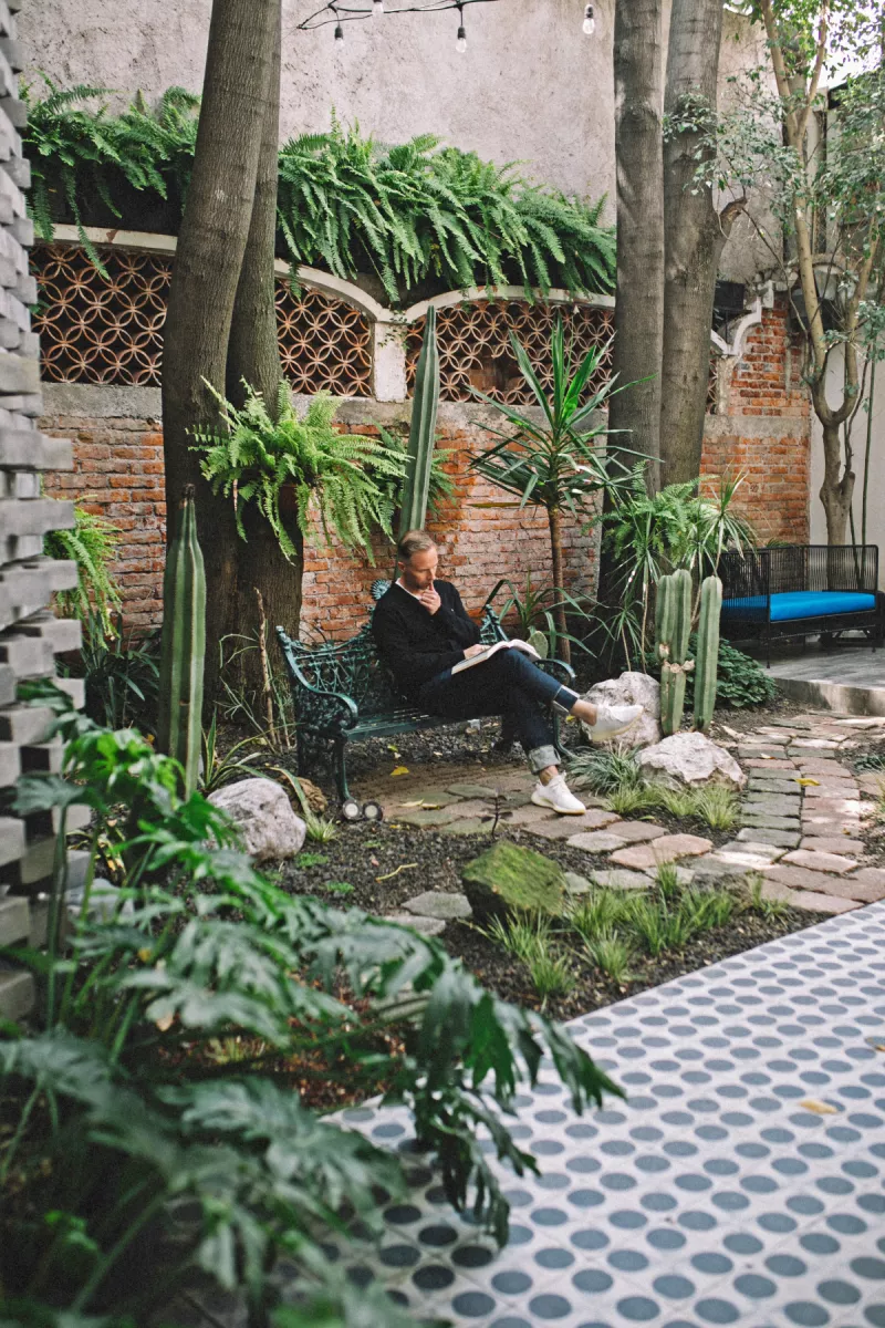 viajero sentado en el jardín, al interior de las instalaciones del hotel boutique Pug Seal.