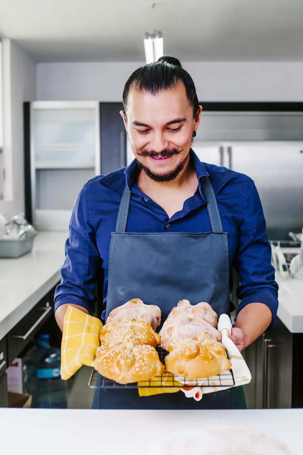 Mexican man cooking Pan de Muerto Traditional bread for day of the dead in Mexico