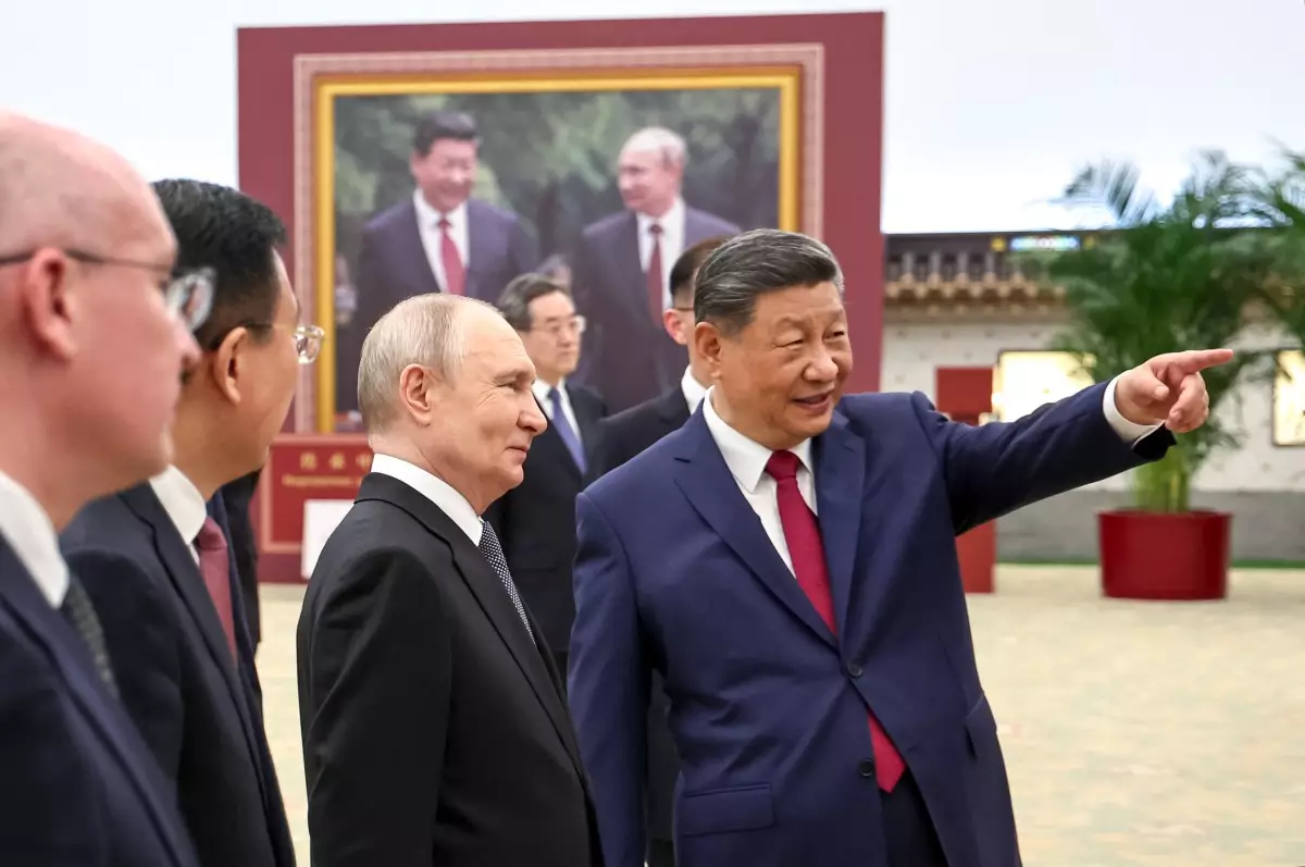 En esta fotografía de la piscina distribuida por la agencia estatal rusa Sputnik, el presidente ruso Vladimir Putin y el presidente chino Xi Jinping recorren una exposición fotográfica sobre los lazos entre Rusia y China en Beijing el 20 de mayo de 2026.
