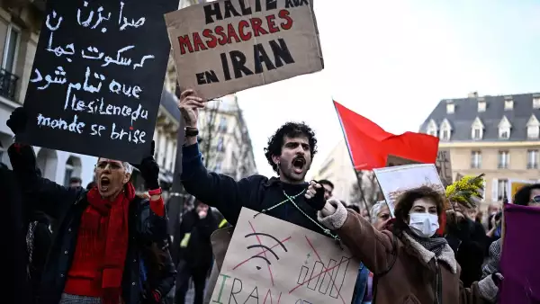 Un manifestante sostiene un cartel que dice "Alto a las masacres en Irán" durante una manifestación en apoyo del pueblo iraní en París el 17 de enero de 2026.