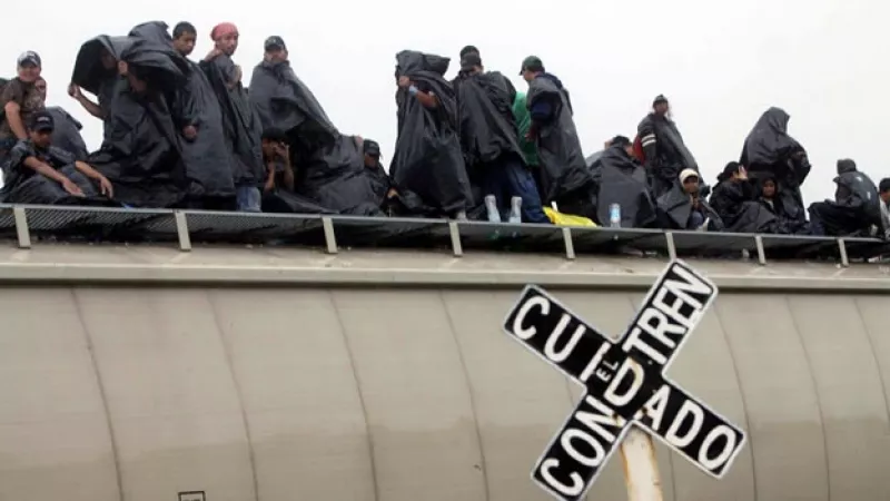 migrantes viajan a bordo de un tren