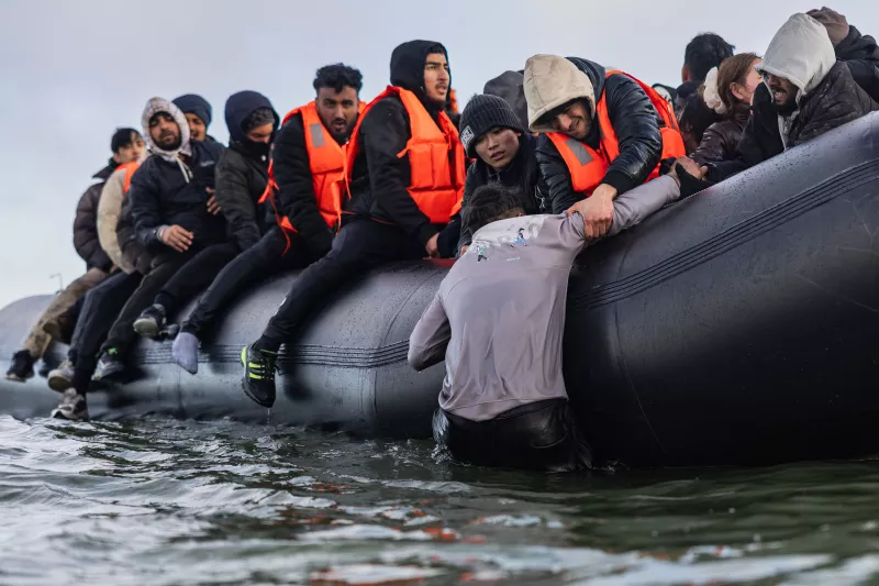 Migrantes suben a una embarcación de contrabandistas en un intento de cruzar el Canal de la Mancha, frente a la playa de Gravelines, al norte de Francia, el 26 de marzo de 2025.