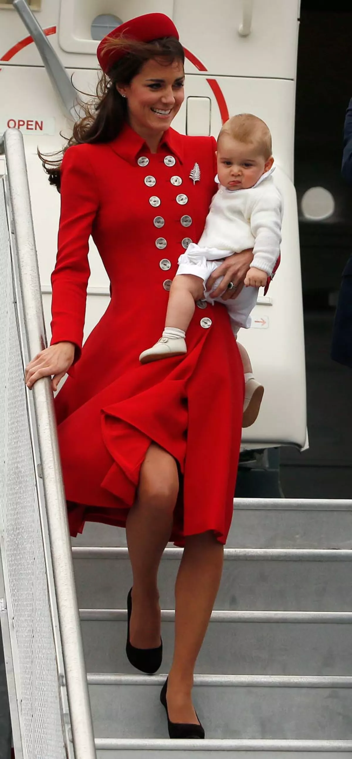 Bajándose de un avión y cargando a su hijo George, la duquesa no deja los tacones.