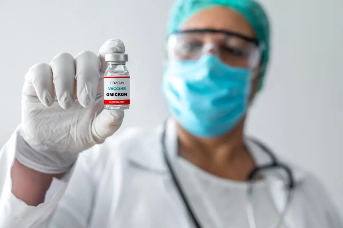 Médico sostiene una vacuna contra el coronavirus, variante omicron. 