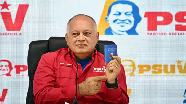 El Ministro de Relaciones Interiores, Justicia y Paz de Venezuela, Diosdado Cabello, muestra una copia de la constitución venezolana mientras habla durante una conferencia de prensa del Partido Socialista Unido de Venezuela (PSUV) en Caracas, el 15 de diciembre de 2025.