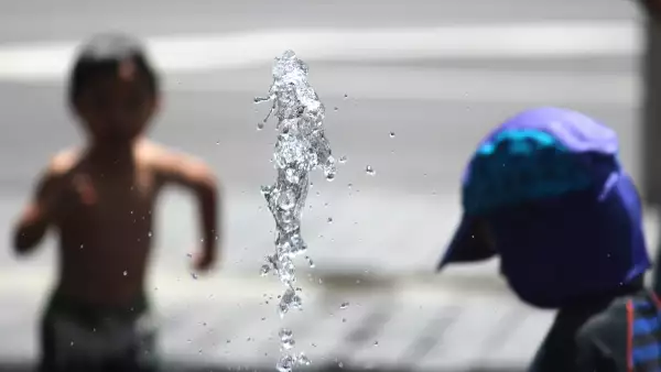 Dos niños juegan en una fuente. 