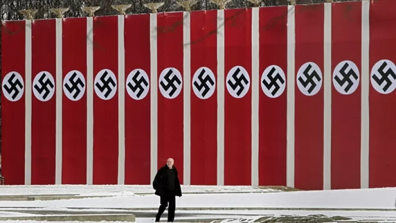 un hombre pasa ante banderolas con la cruz gamada en berlin