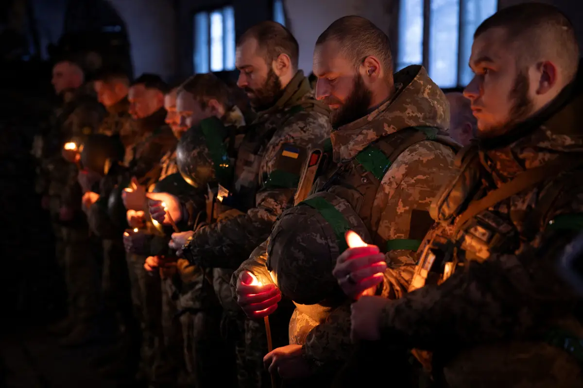 Los soldados ucranianos de la 14a brigada mecanizada separada sostienen velas durante un servicio de Nochebuena cerca de la línea del frente a las afueras de Kupiansk mientras los ucranianos celebran su primera Navidad de acuerdo con un nuevo calendario, en medio del ataque de Rusia a Ucrania, el 24 de diciembre de 2023.