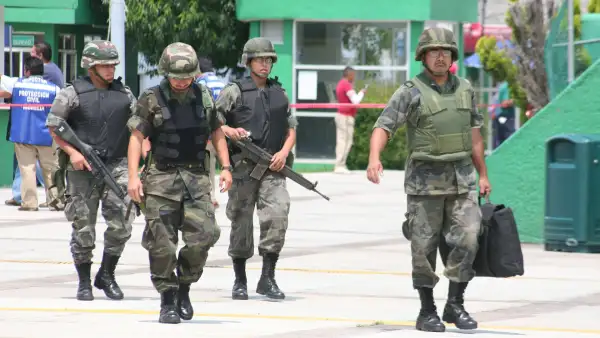 Cuatro elementos de las Fuerzas Armadas caminan con armas tras amenaza de bomba en Morelia durante las fiestas patrias de 2008. 