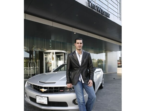 Mike al llegar al hotel en un coche Chevrolet Camaro Convertible.