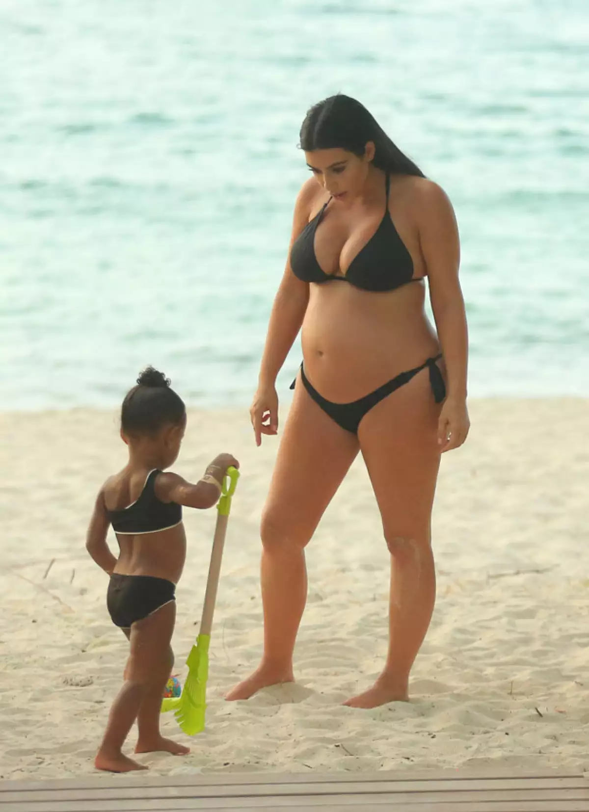 Durante su paseo por la playa, North jugaba con su madre y sus brazos tenían tatuajes falsos dorados.