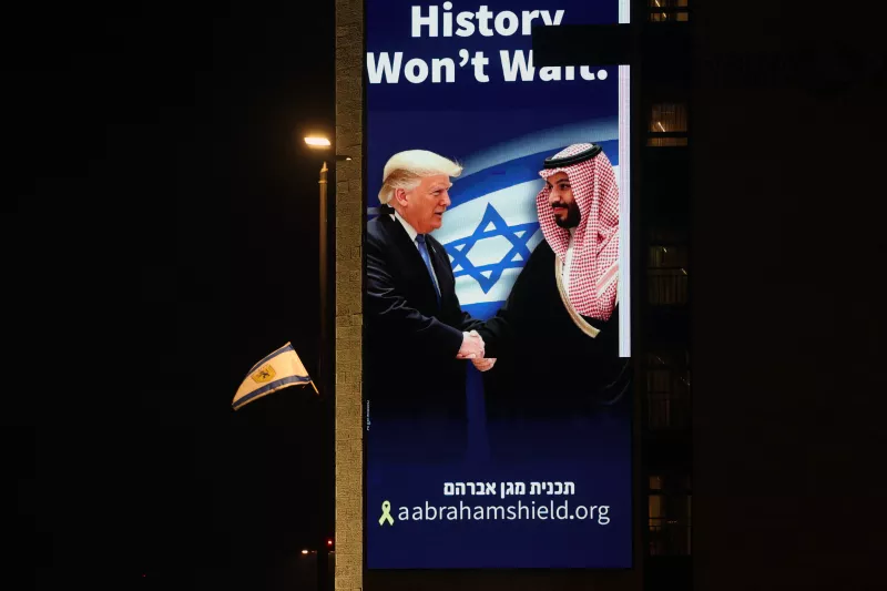 Una valla publicitaria con una imagen del presidente de Estados Unidos, Donald Trump, estrechando la mano del príncipe heredero saudí, Mohammed bin Salman, con el lema encima: «history won't wait » "la historia no esperará"
