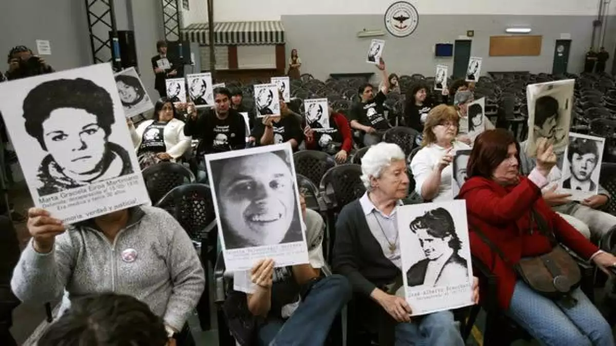 Familiares sostienen fotografías de desaparecidos durante la dictadura argentina (1976-1983)