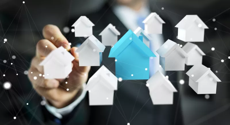 Businessman on blurred background using 3D rendered small white and blue houses