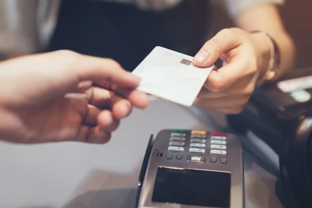 Concept of technology in buying without using cash. Close up of hand use credit card swiping machine to pay.