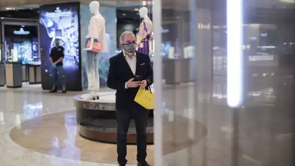 (Un hombre observa los escaparates de una tienda departamental)