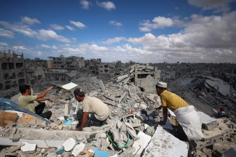 Los palestinos registran los escombros de los edificios en medio de la destrucción generalizada debido al bombardeo israelí en Khan Yunis, en el sur de la Franja de Gaza, mientras se celebra un alto el fuego el 12 de octubre de 2025. Un alto el fuego en Gaza se celebraba por tercer día el 12 de octubre, antes de un intercambio de rehenes-prisisioneros propuesto por Estados Unidos y una cumbre destinada a trazar un camino hacia la paz después de dos años de guerra.