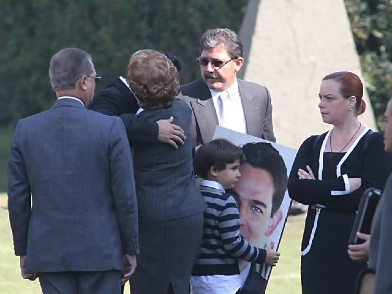 Iván, hijo de Juan Camilo Mouriño, sujeta la foto con el rostro de su padre durante el homenaje en Campo Marte.