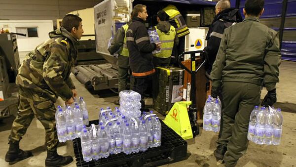 Miles de toneladas de comida, agua y medicamentos han empezado a llegar al aeropuerto de la ciudad de Puerto Principe. En la foto, bomberos franceses se alistan para ayudar descargando agua y otros alimentos.