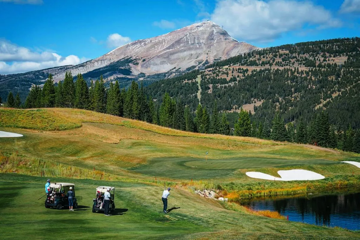 Foto del club de golf del Yellowstone Club en Montana con las montañas nevadas de frente.