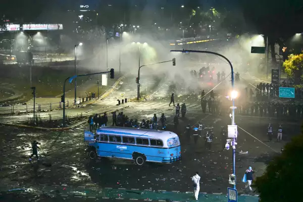 Los fanáticos argentinos se enfrentan a la policía antidisturbios en el Obelisco después de que Argentina perdiera el partido final de fútbol de la Copa Mundial de la FIFA contra España en Buenos Aires el 19 de julio de 2026. España ganó por 1-0.
