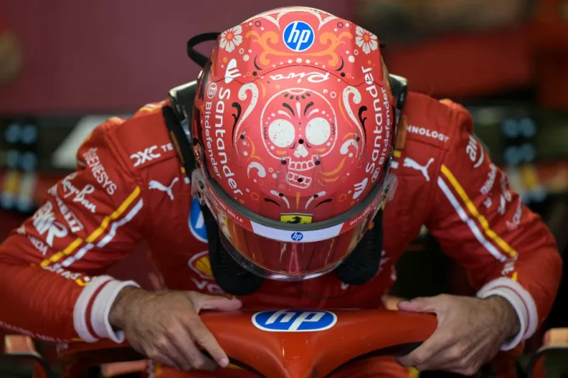 Foto de Carlos Sainz saliendo de su monoplaza con un casco rojo y el dibujo de una catrina