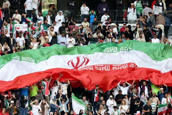 Los fanáticos de Irán celebran con una bandera después de que Alireza Jahanbakhshsh de Irán anotara el segundo gol de su equipo desde el punto de penalti durante el partido de cuartos de final de la Copa Asiática de la AFC entre Irán y Japón en el Education City Stadium el 3 de febrero de 2024 en Al Rayyan, Qatar.
