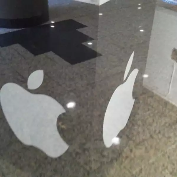 Un cubo con el logo de Apple sostiene publicidad de la tienda.