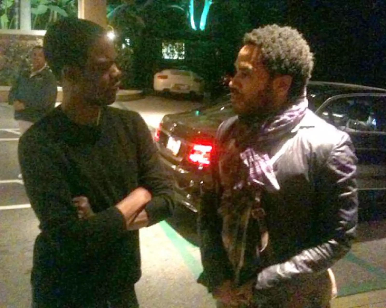 Chris Rock y Lenny Kravitz platicando en la calle.