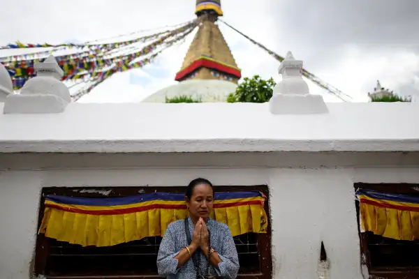 Una mujer reza durante una vigilia en homenaje a las víctimas de las inundaciones repentinas en la estupa de Boudhanath, en Katmandú, el 1 de septiembre de 2026. Las devastadoras inundaciones en la frontera entre China y Nepal han causado la muerte de al menos 987 personas en Nepal —según informó el 1 de septiembre la autoridad encargada de la gestión de desastres—, elevando la cifra total de fallecidos a más de 1.000. (Foto de Manan VATSYAYANA / AFP)