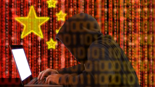 Chinese hacker at work in front of red flag