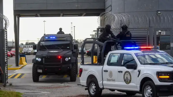 En la imagen se observan patrullas custodiadas por policías armados.