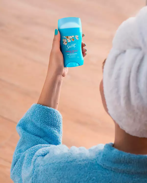 Desodorante Secret en la mano de una mujer en bata.jpg