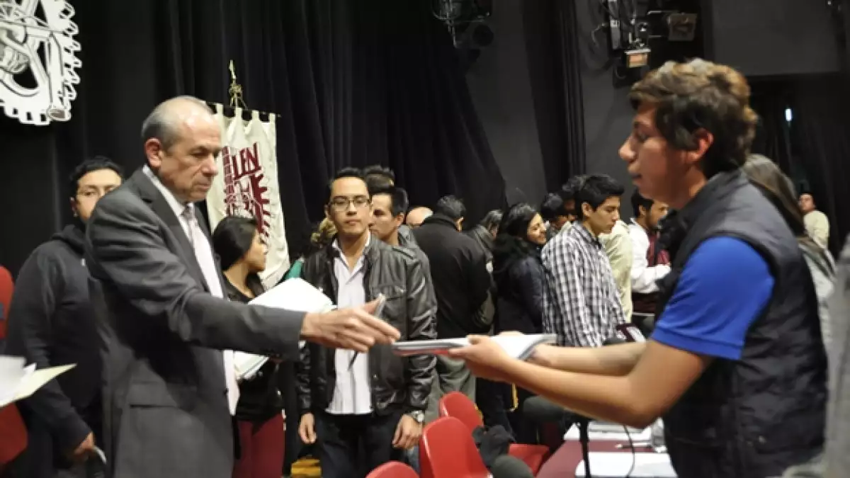 El director del IPN Enrique Fernández Fassnacht (izquierda) recibe los acuerdos a los que se llegó con estudiantes para reanudar clases