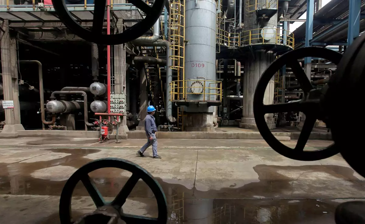 (Un trabajador pasa junto a tuberías de petróleo en una refinería en Wuhan, provincia de Hubei)