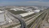 Fotografía aérea en la que se observan parques industriales junto a vías de transporte en México.  