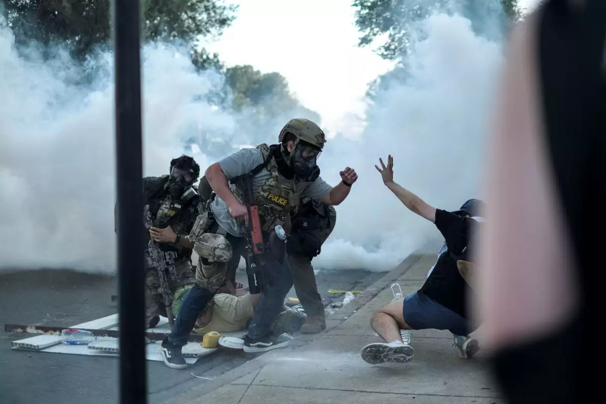 Un agente del orden se enfrenta a un manifestante, mientras otro es detenido, durante un enfrentamiento con el Servicio de Inmigración y Control de Aduanas de Estados Unidos (ICE) y agentes federales en el barrio de Little Village de Chicago, Illinois, EE. UU., el 4 de octubre de 2025.