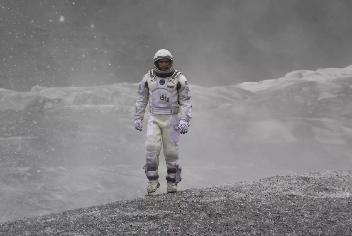 Foto de Matthew McConaughey vestido como astronauta en un mundo gris y lleno de nieve en una escena de la película Interstellar.