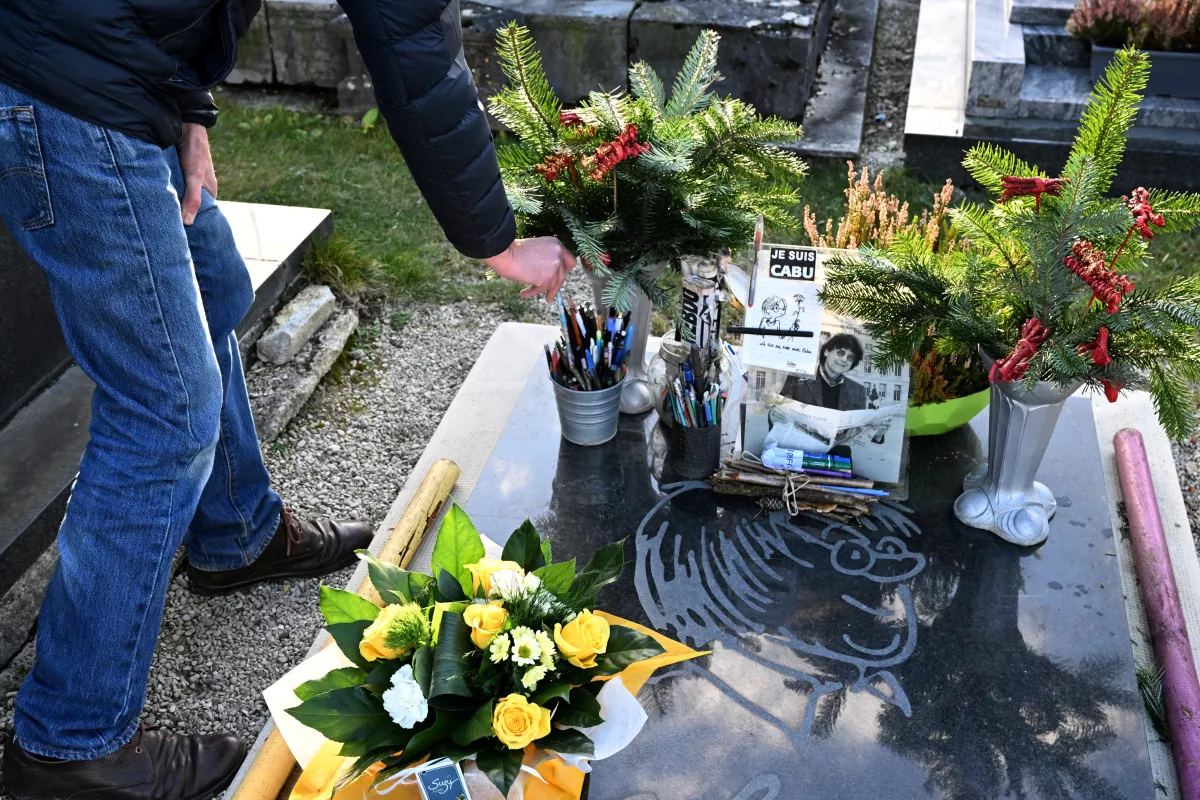 Un hombre coloca un bolígrafo sobre la tumba de Cabu, diseñador asesinado hace 10 años en un atentado islamista contra el periódico satírico Charlie Hebdo, en Chalons-en-Champagne, norte de Francia, el 7 de enero de 2025.