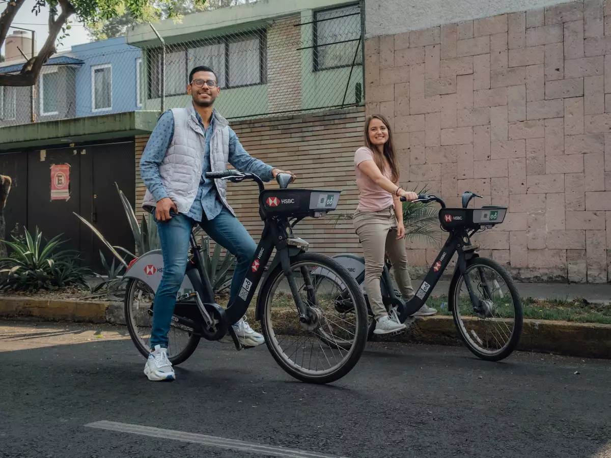 Dos jóvenes posan para una foto usando una Ecobici que es una alternativa divertida y saludable para trasladarse al trabajo, a la escuela o para recorrer las calles y visitar sitios de interés.