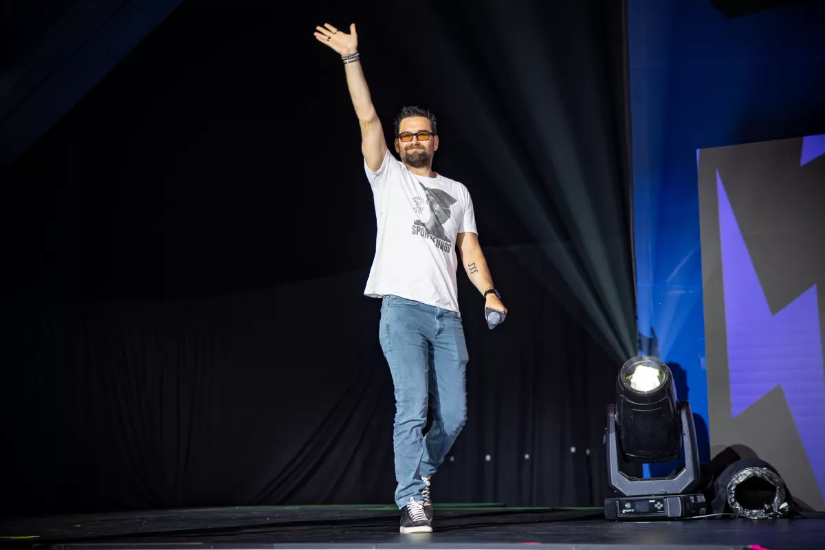Foto del actor Antony Starr saludando con la mano en alto al entrar al escenario del Thunder Stage del CCXP México 2024.