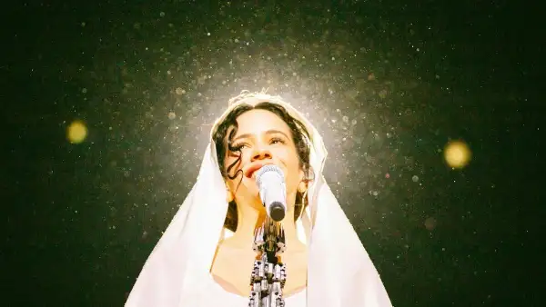Retrato de Rosalía durante su concierto Lux Tour. En la imagen se ve a la cantante barcelonesa con un Manto blanco en la cabeza mientras interpreta el tema "Mio Cristo Piange Diamanti". 