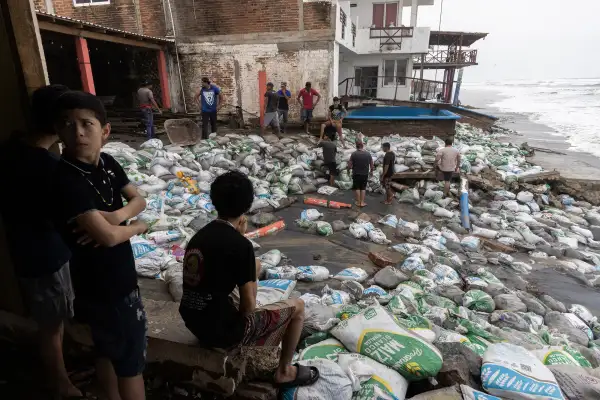 Negocios frente al mar en Lázaro Cárdenas, Michoacán, protegidos con costales de arena ante el oleaje del huracán Polo.