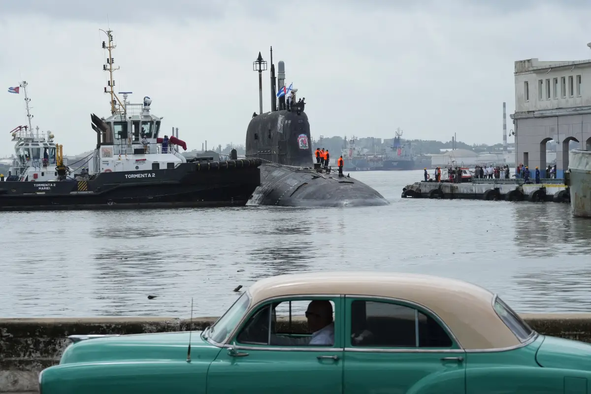 Barcos rusos en Cuba: Un coche antiguo pasa mientras el submarino ruso de misiles de crucero de propulsión nuclear Kazan atraca en la bahía de La Habana, el 12 de junio de 2024.
