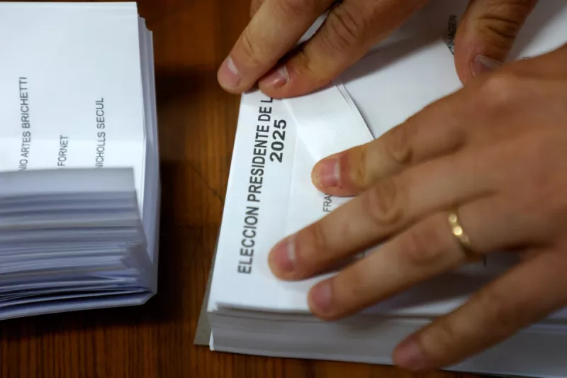 Un funcionario electoral dobla papeletas durante las elecciones generales, en la comuna de Providencia, Santiago, el 16 de noviembre de 2025.